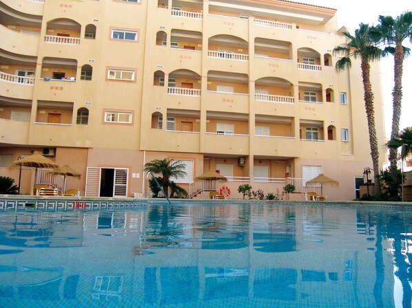 Piscine extérieure, parasols de plage, chaises longues