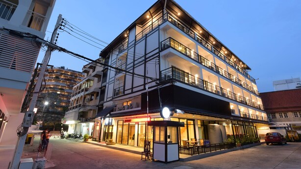 A multi-story hotel with balconies, a ground-level restaurant, and a parking area. - The Golden Ville Boutique Hotel & Spa (Pattaya)