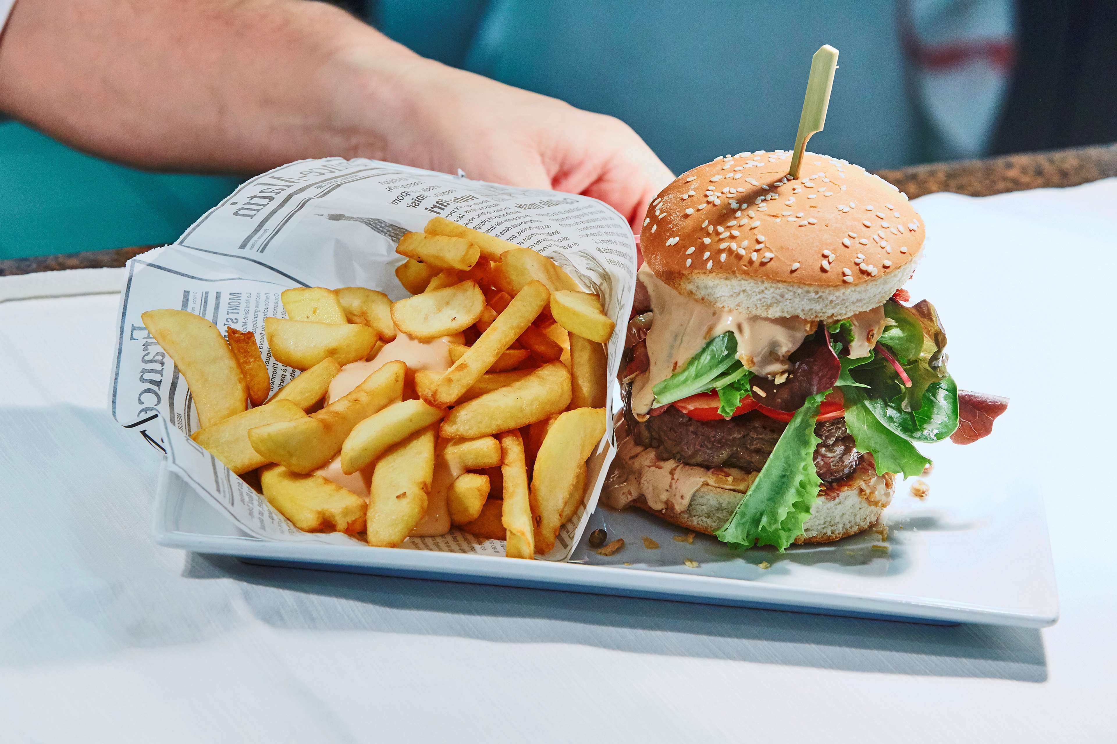 A meal consisting of a burger and fries on a white plate.