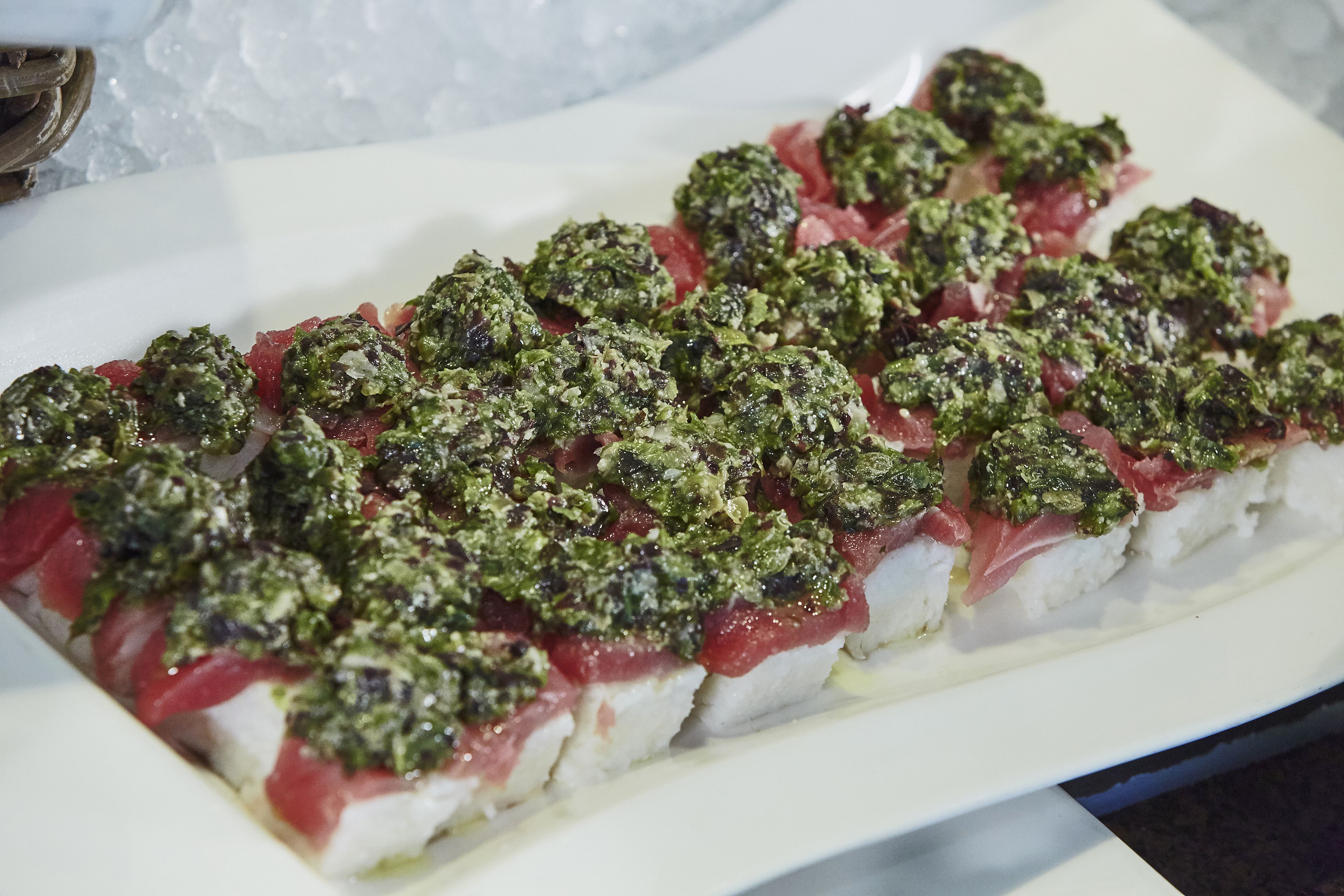 A sushi platter with various toppings on a white plate.