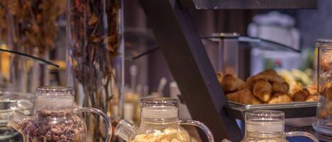 A buffet setup with various food items and beverages in glass containers, arranged on wooden stands.