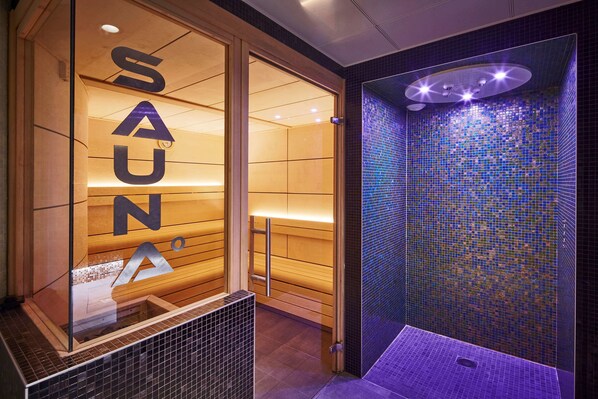 A sauna room with a tiled wall and a wooden door.