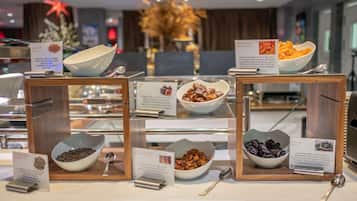 A buffet with various food items displayed in bowls, accompanied by informational signs.