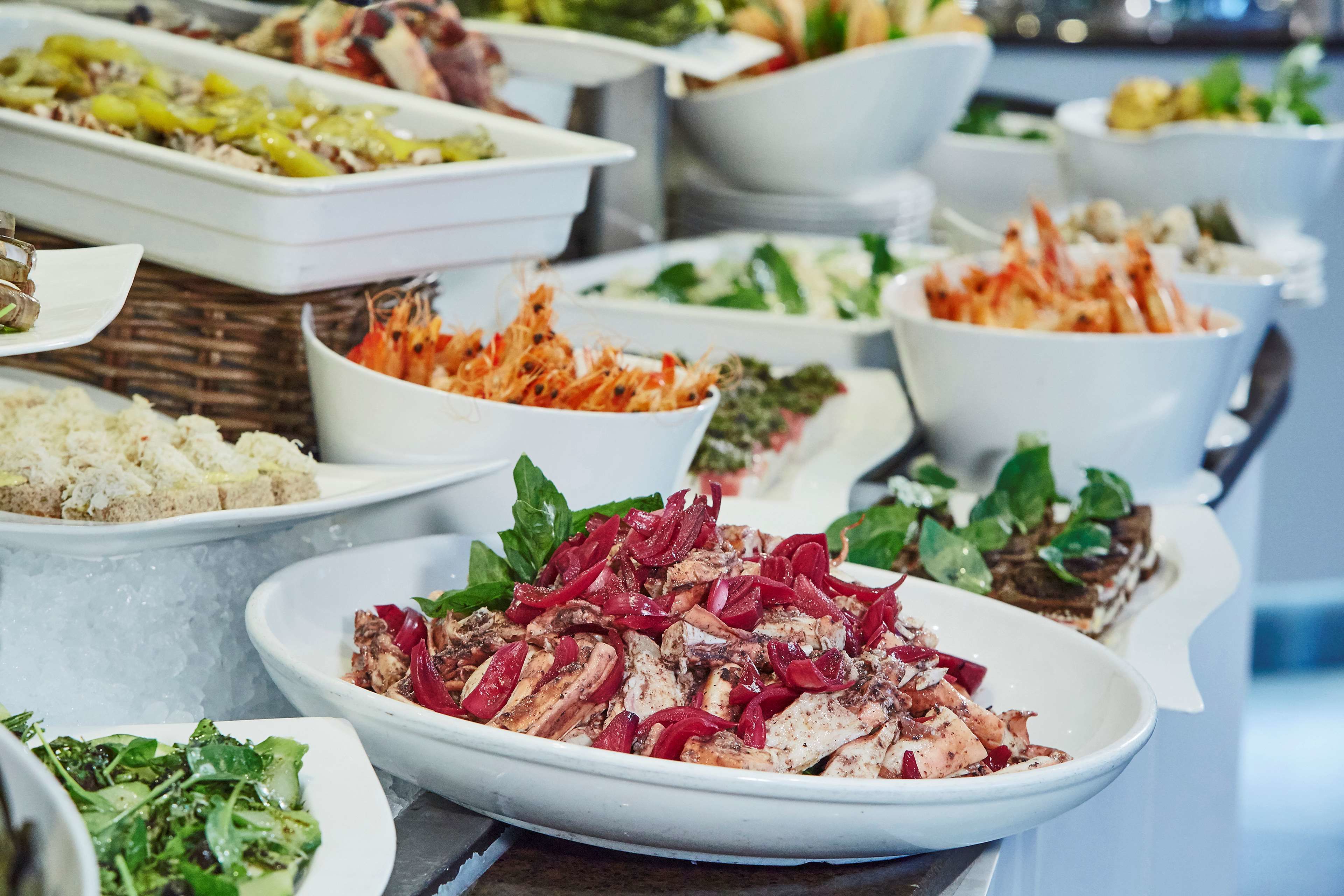 A buffet with various dishes including salads, rice, and seafood.