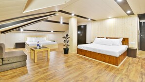 A spacious room with a large bed, a wooden floor, and a ceiling with exposed beams. - Hotel Devlok (Manali)