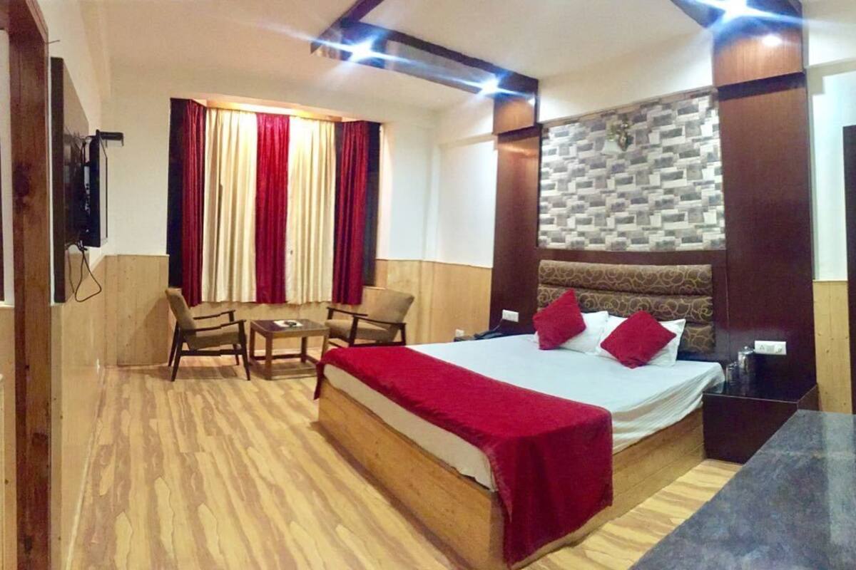 Una habitación de hotel con cama, escritorio, silla y televisor.
