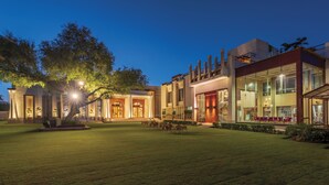 A modern hotel with a spacious courtyard, large windows, and a well-lit entrance.