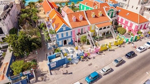 Ein farbenfrohes Hotel mit einem blauen Gebäude mit der Aufschrift "SCUBA LODGE" und einem pinken Gebäude mit einem Schild "DANIEL'S".