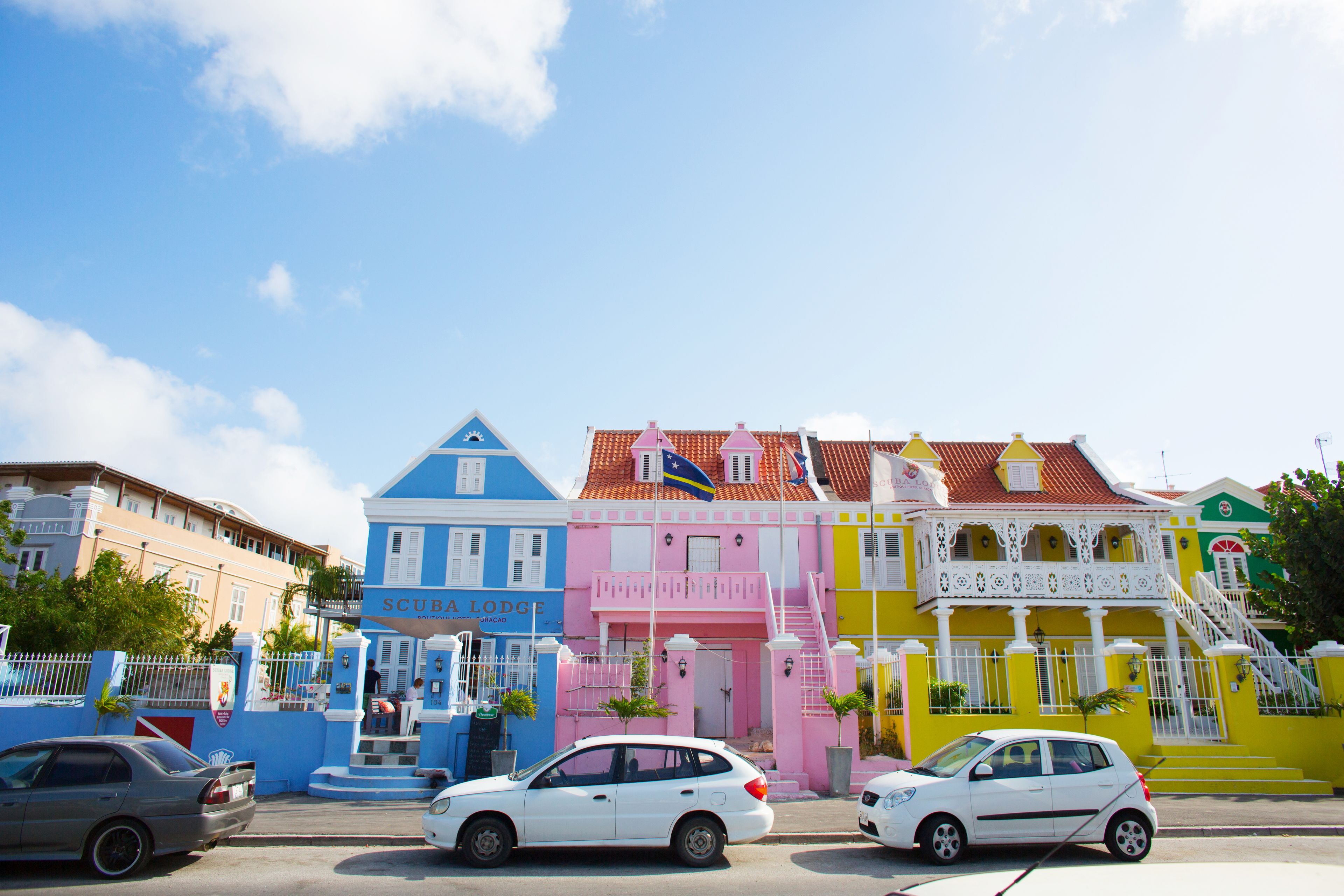 Een rij kleurrijke gebouwen met een blauwe, roze, gele en groene gevel.