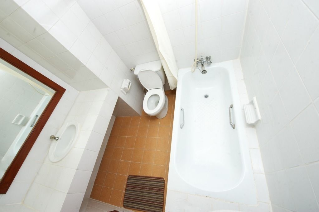 A bathroom with a bathtub, toilet, and bidet.