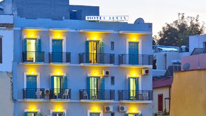 Un hotel de varios pisos con balcones y un cartel que dice "HOTEL LUCIA".