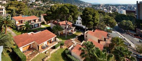 Zona residencial con casas que tienen tejados rojos y abundante vegetación, incluyendo palmeras.