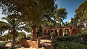 A stone pathway leading to an arched building with a garden and palm trees. - Bonanza Park Hotel by Olivia Hotels Collection (Calvia)