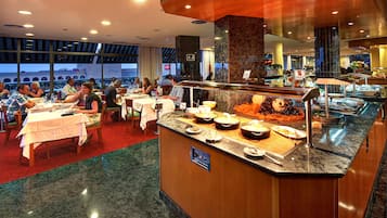 Buffet-alue, jossa on tarjolla monipuolista ruokaa ja erillinen palvelutiski.