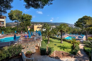 A resort with multiple swimming pools, sun loungers, and umbrellas.