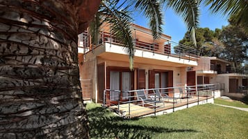 A two-story building with a balcony and a pool area.