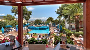 A poolside area with lounge chairs and umbrellas, a pool, and potted plants. - Bonanza Park Hotel by Olivia Hotels Collection (Calvia)