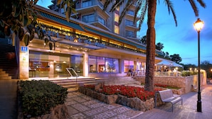 A hotel with a modern facade, outdoor seating area, and a well-lit entrance. - Bonanza Park Hotel by Olivia Hotels Collection (Calvia)