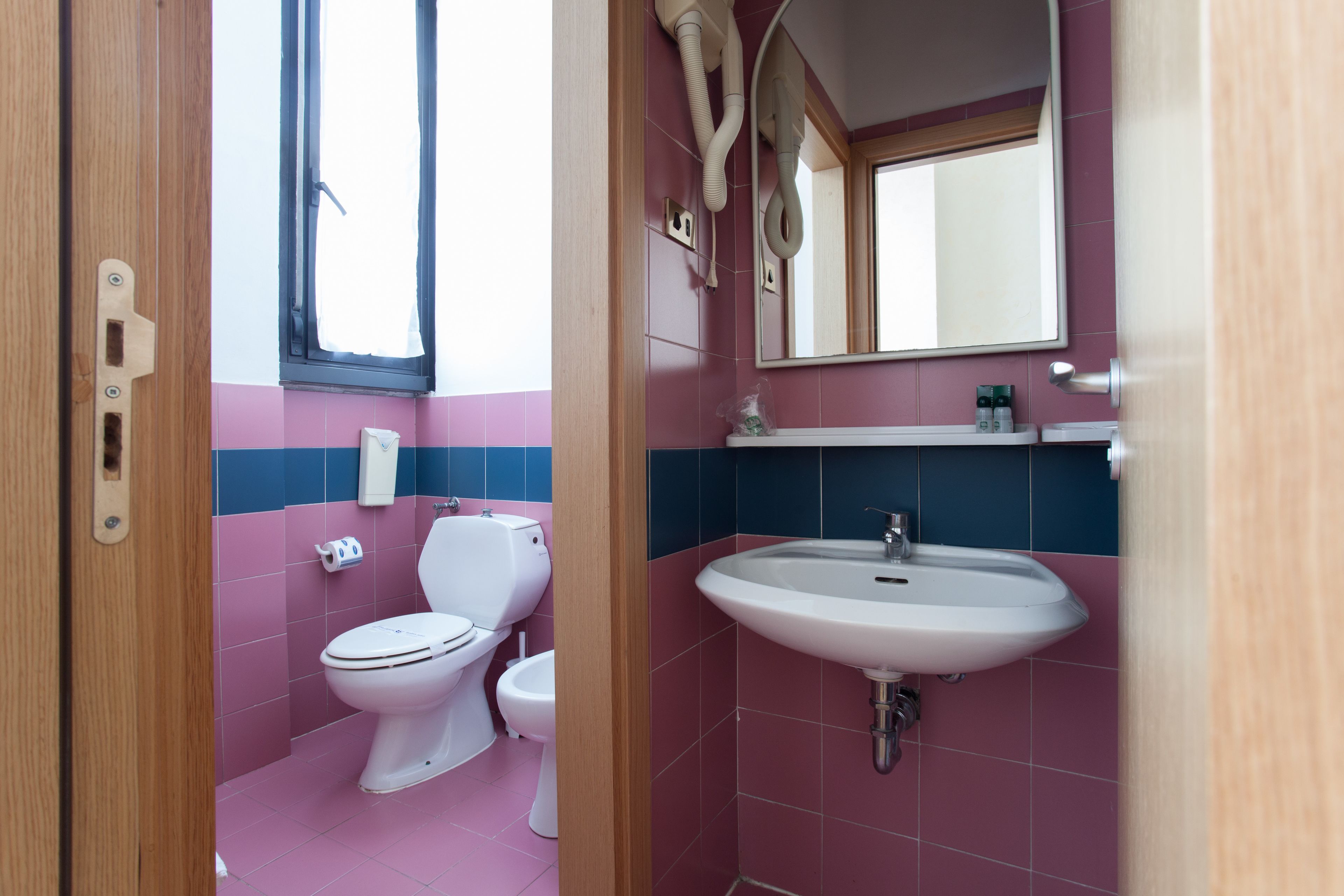 Un baño con inodoro, bidé y lavamanos.