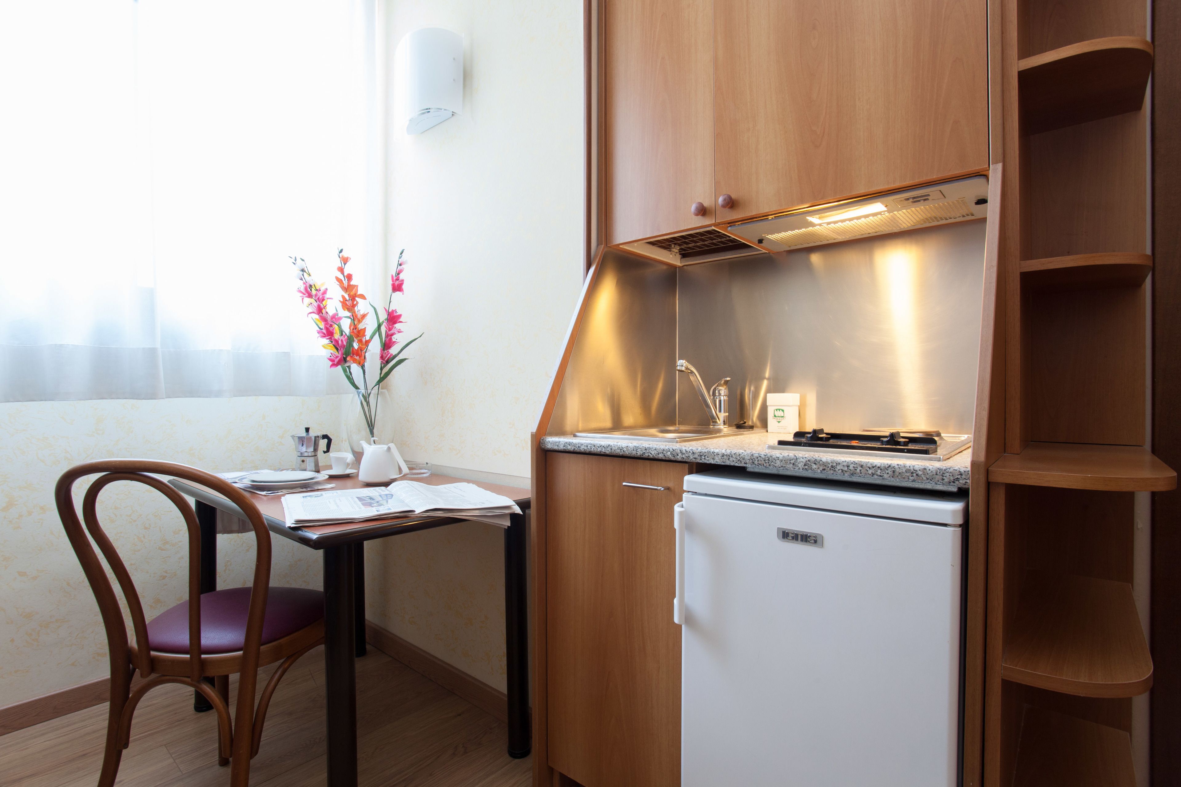 Une petite cuisine équipée comprenant un réfrigérateur, un évier et un plan de travail.