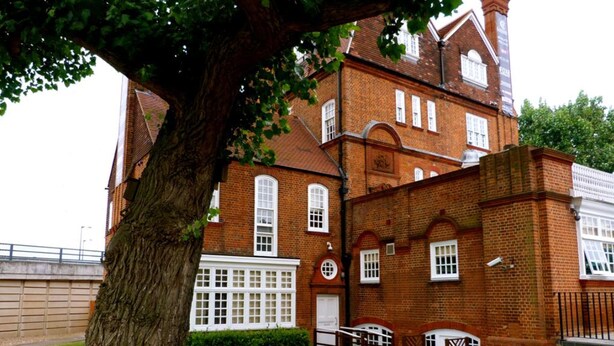 A traditional brick building with multiple windows and a large tree in the foreground. - Fox Connaught (London)