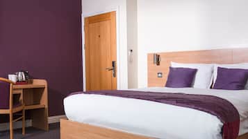 Un dormitorio con cama de madera, un escritorio y una puerta.