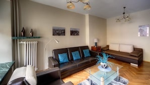 A modern living room with a sofa, a glass coffee table, and decorative items. - Apartment Central (Wroclaw)