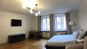 A bedroom with a bed, a desk, and a TV. - Apartment Central (Wroclaw)