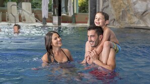 Una familia en una piscina, con un niño sobre los hombros de un adulto.