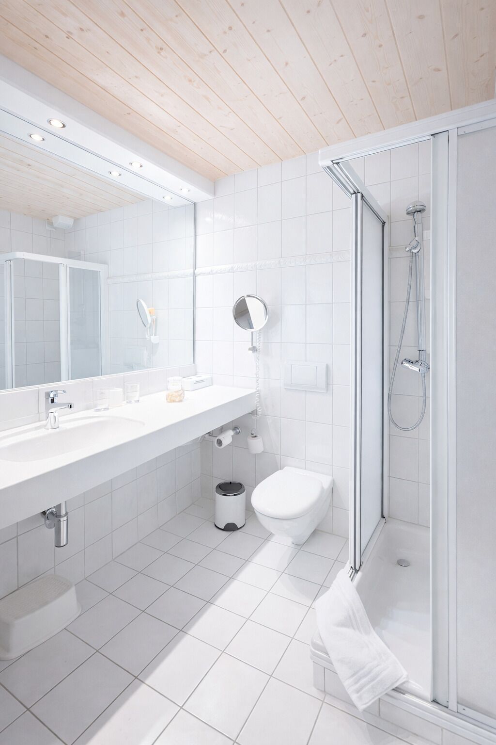 A modern bathroom with a shower, toilet, and sink.
