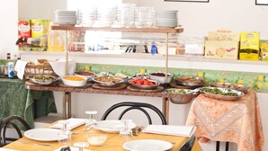 Un buffet con diversi cibi, condimenti, piatti e posate disposti su un tavolo.