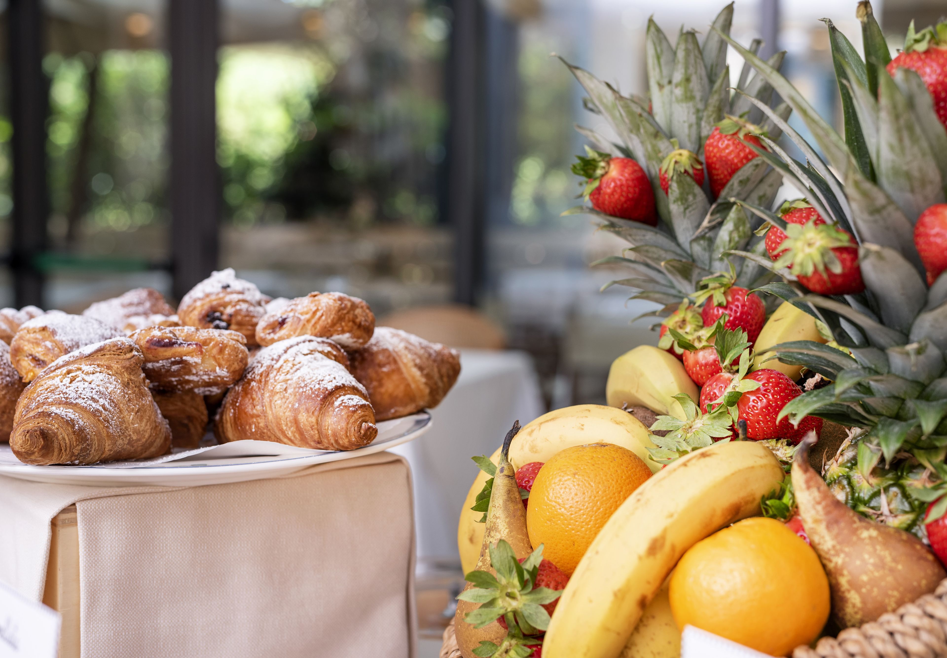 A table with pastries and a fruit arrangement.