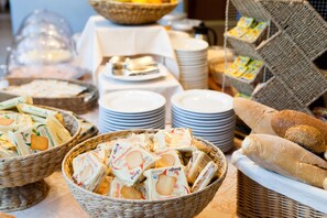 A buffet table with various food items and bread. - Hotel Andreaneri (Pietrasanta)