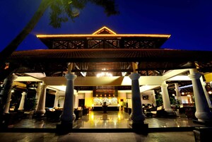 A hotel lobby with a reception desk, large columns, and a traditional architectural design.