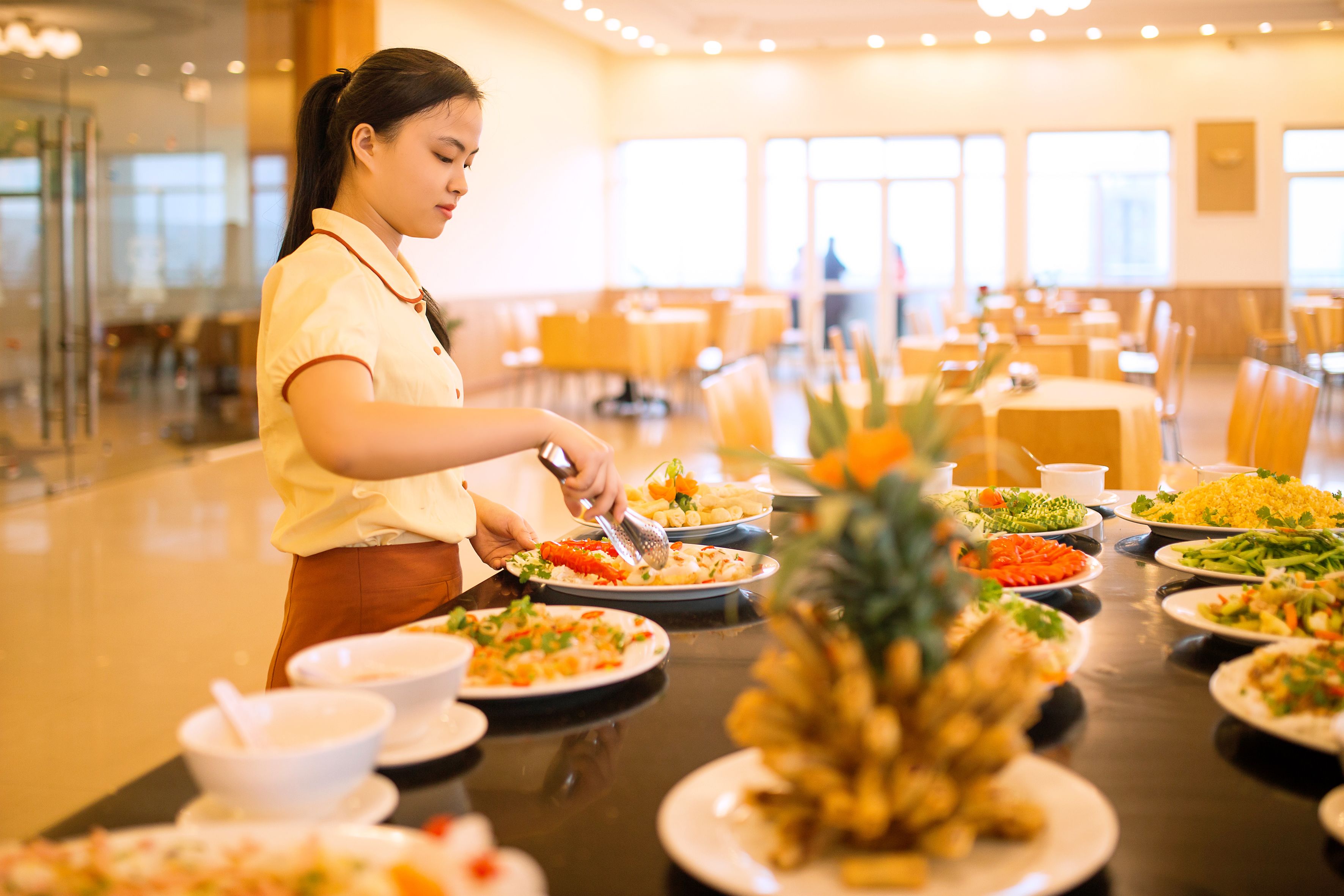 A buffet setup with various dishes and a pineapple centerpiece.