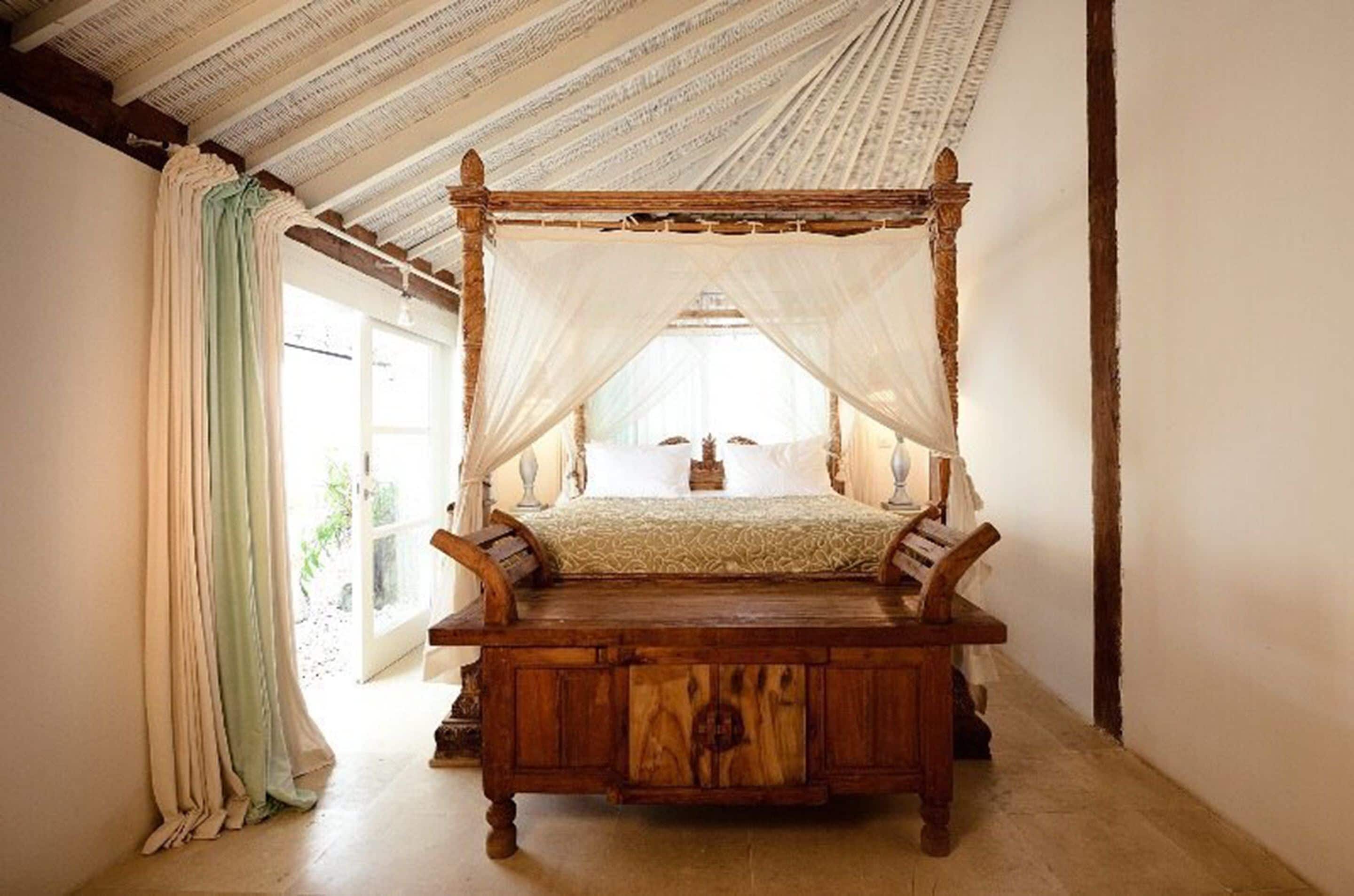 Una cama con dosel, estructura de madera y cubrecama.
