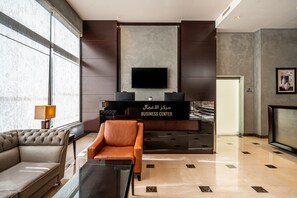 A modern lobby with a sofa, armchair, and a reception desk labeled 'BUSINESS CENTER'. - Doha Central Plaza Hotel (Doha)