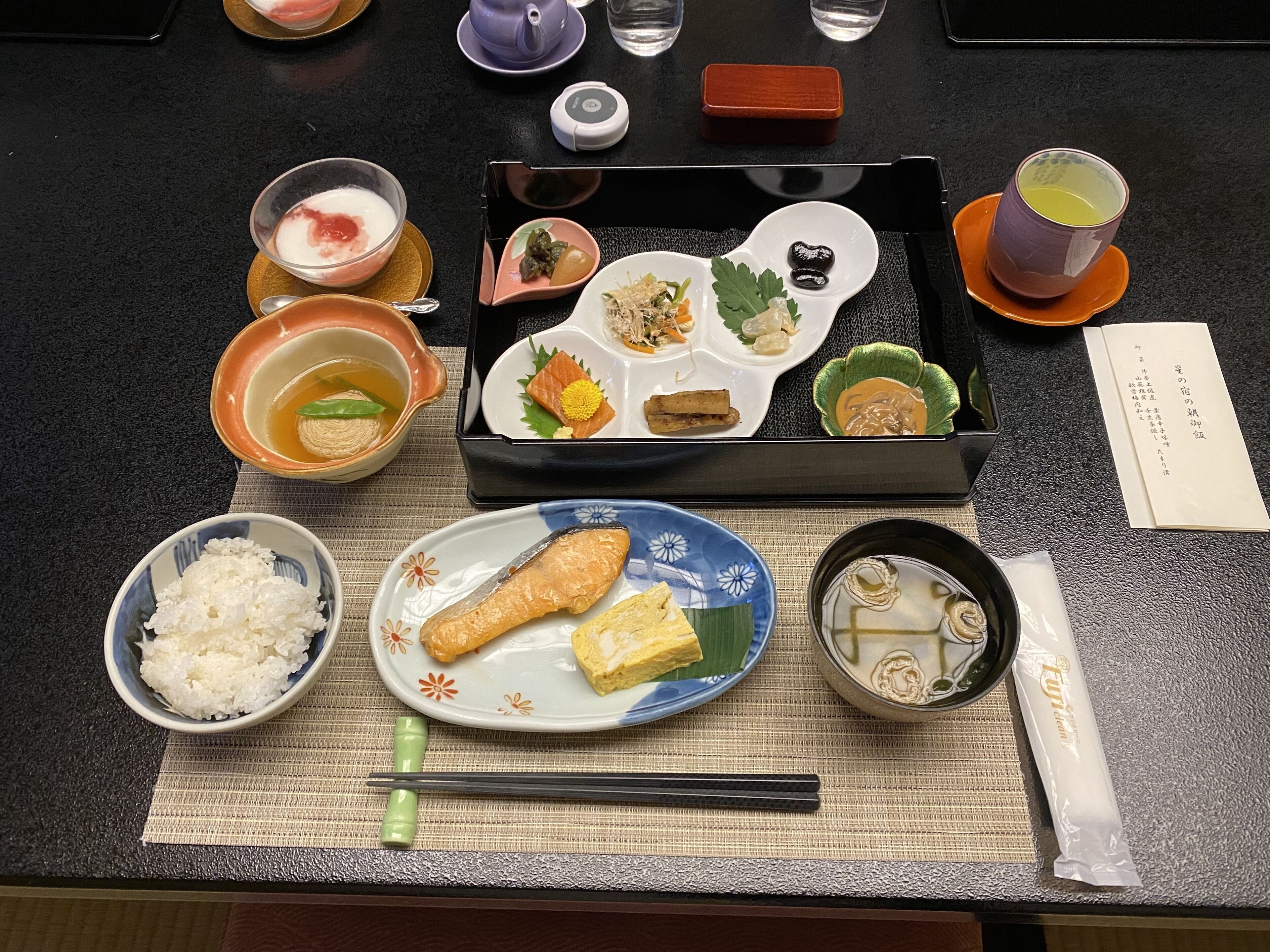 A traditional Japanese meal setup with various dishes and utensils on a table.