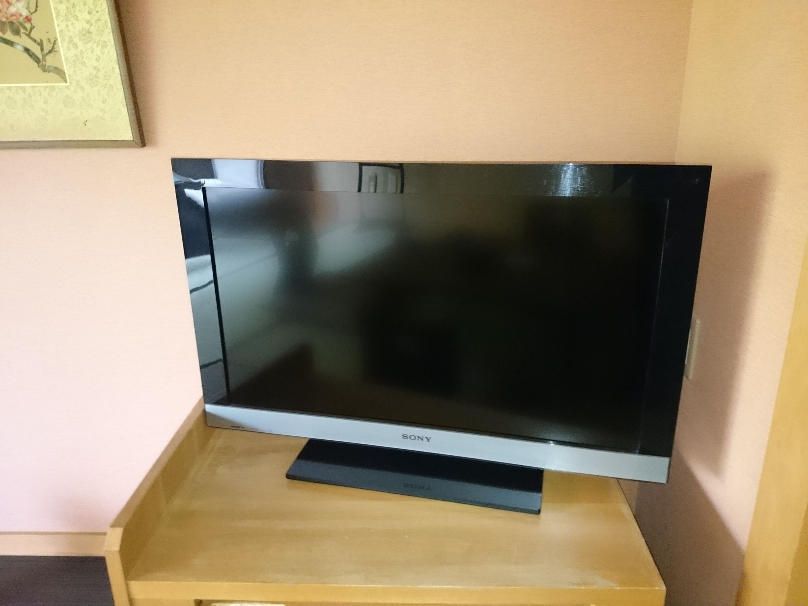 Een flatscreen televisie op een houten standaard.