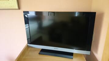 A flat-screen TV on a wooden stand.