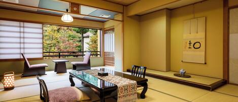 Una habitación japonesa tradicional con suelo de tatami, una mesa baja y vistas a un jardín.