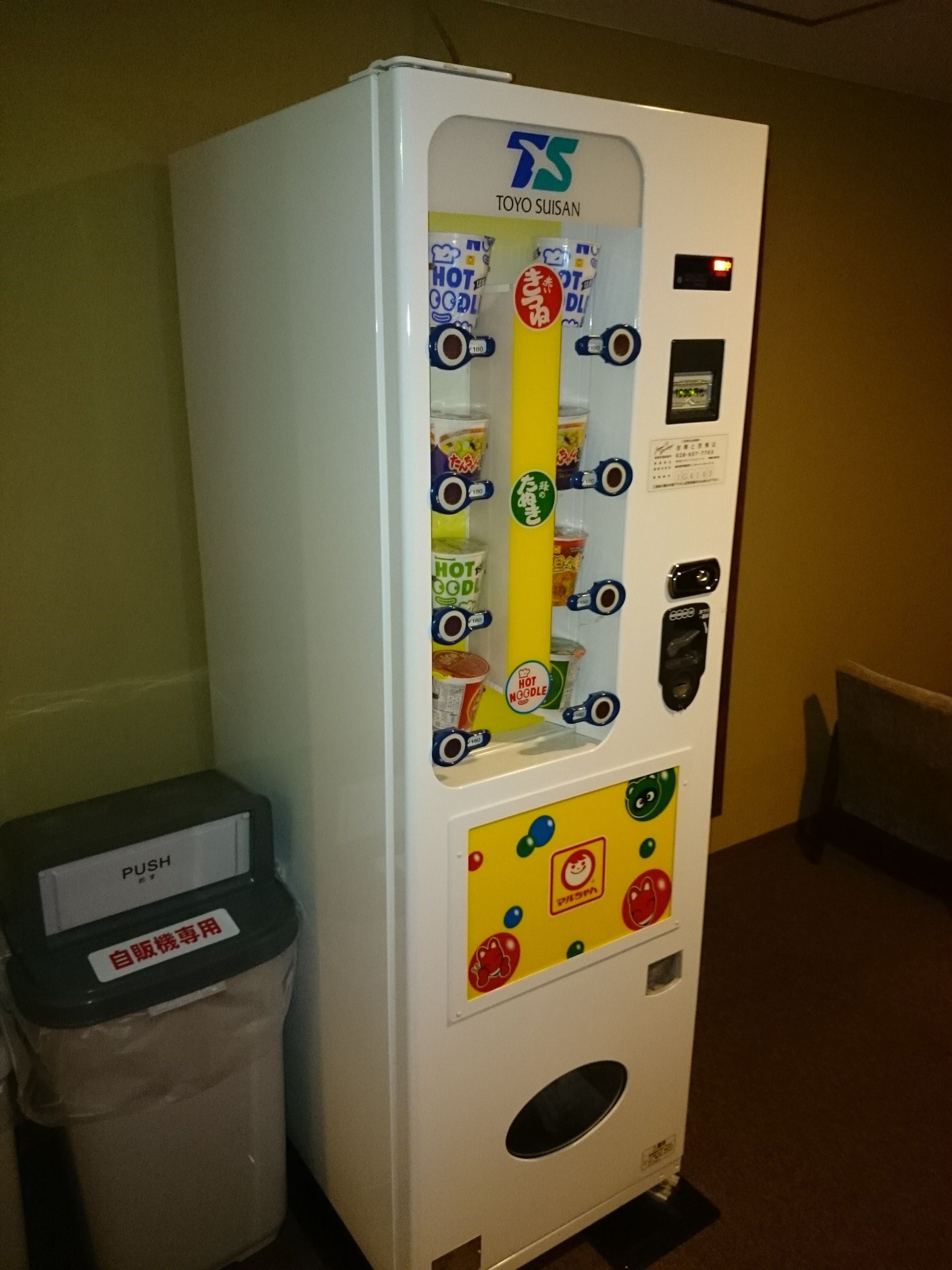 A vending machine with multiple compartments for different types of food, including hot noodles.