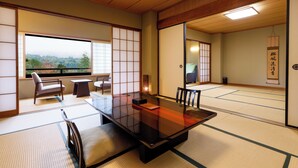 Una habitación japonesa tradicional con suelo de tatami, una mesa baja y puertas correderas.