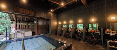 A spa area with a hot tub, wooden benches, and a row of sinks with mirrors.