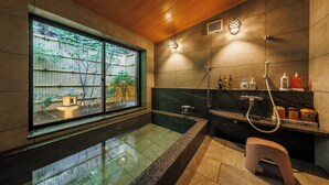 Un baño moderno con un ventanal amplio, una bañera integrada y una zona de ducha.