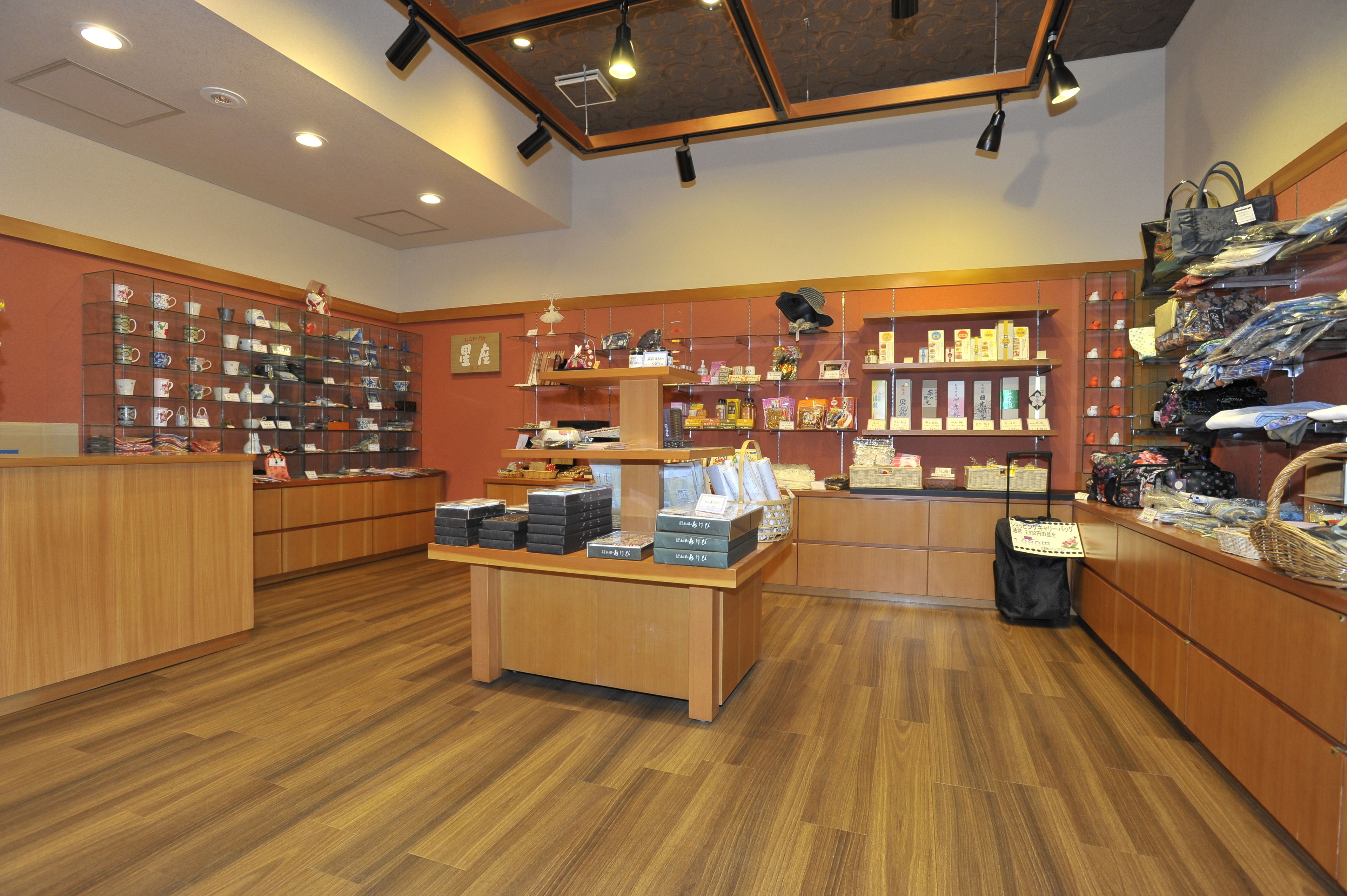 A store with wooden flooring and shelves displaying various items.