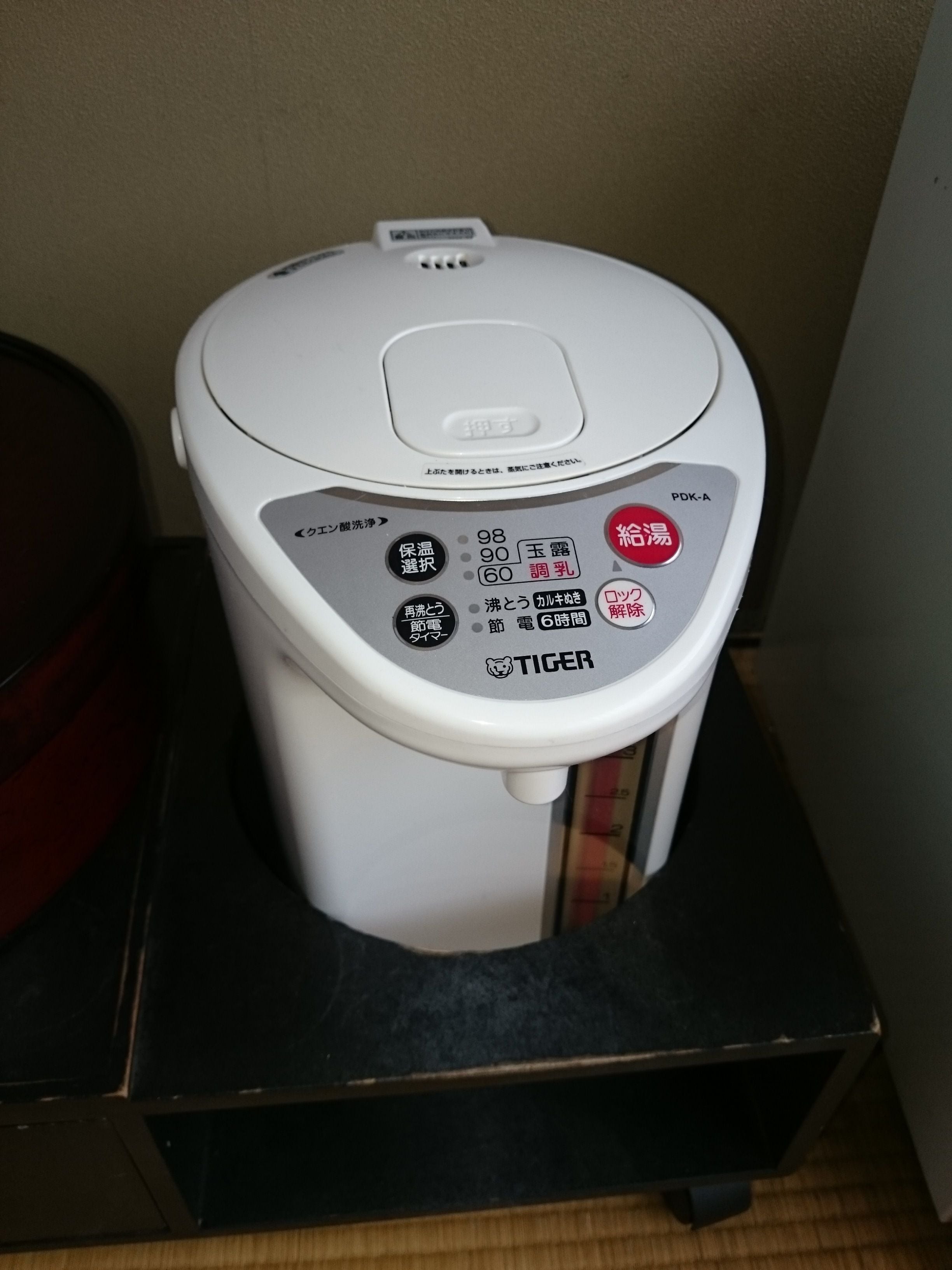 A white electric kettle with a control panel featuring buttons for different functions such as "keep warm," "boil," "power on/off," and "timer."