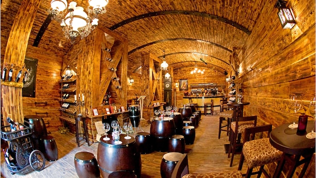 A rustic wooden interior with a bar area, wooden barrels, and a wine rack. - Cadasa Resort Dalat (Xuan Huong - Da Lat)