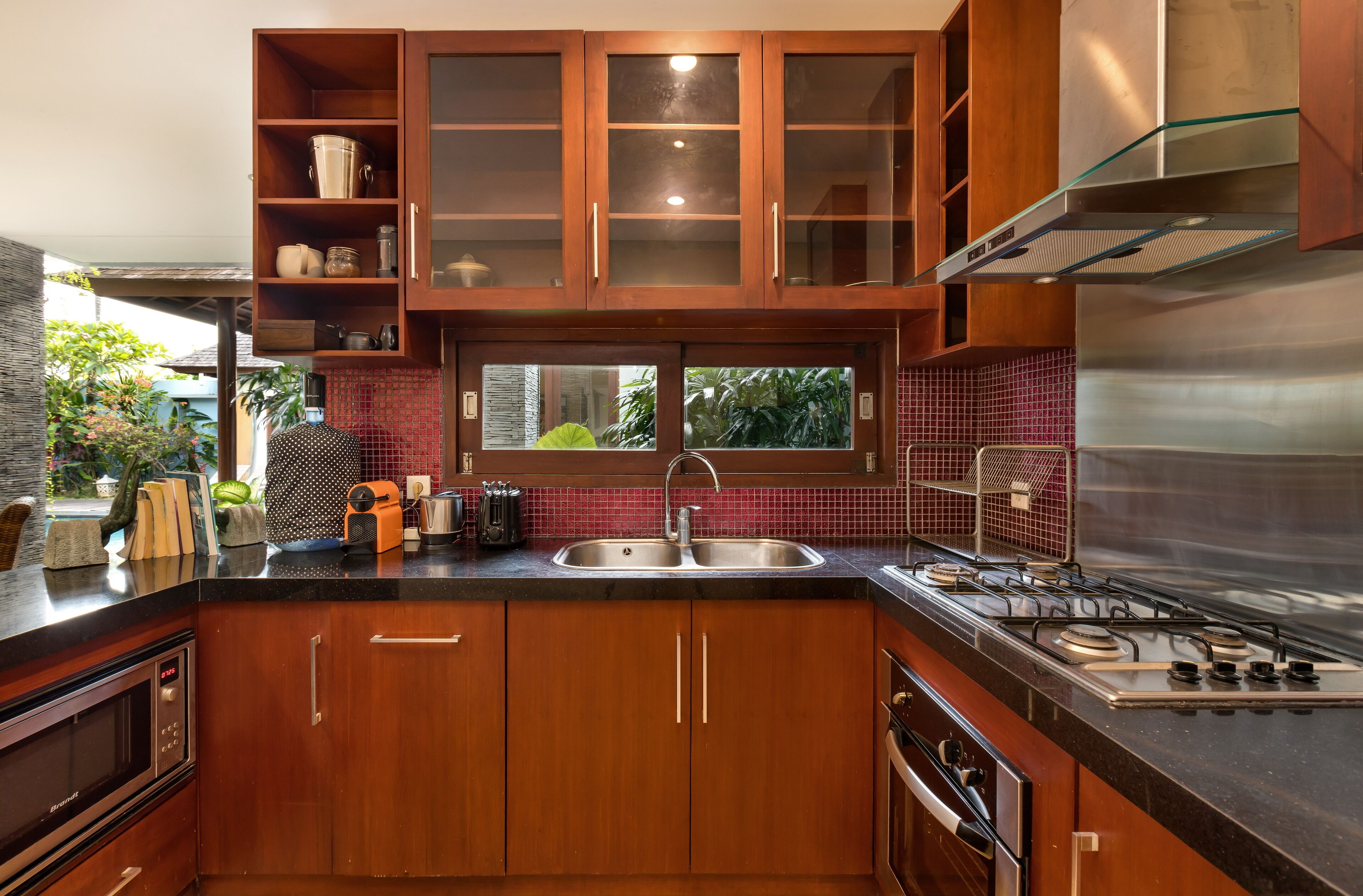 A modern kitchen with wooden cabinets, a stainless steel sink, and a gas stove.