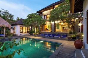 A modern resort with a pool, lounge chairs, and a well-lit outdoor area. - Jabunami Villa (Canggu)